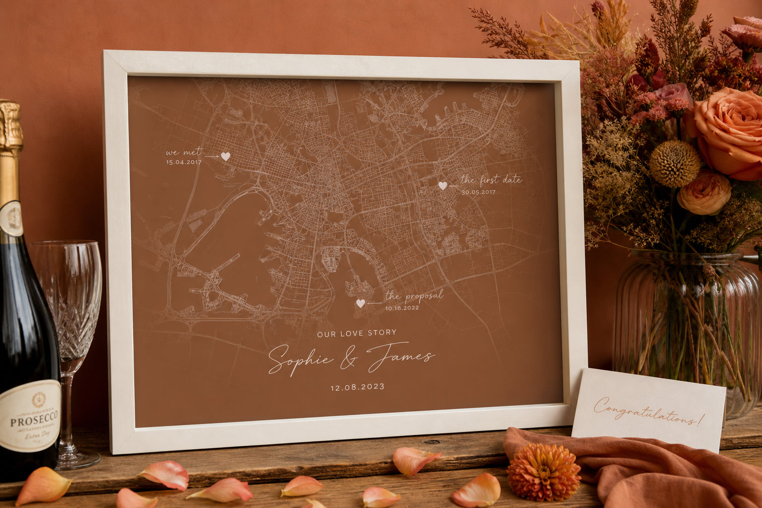 Framed couples map art with partner names on a wedding gift table